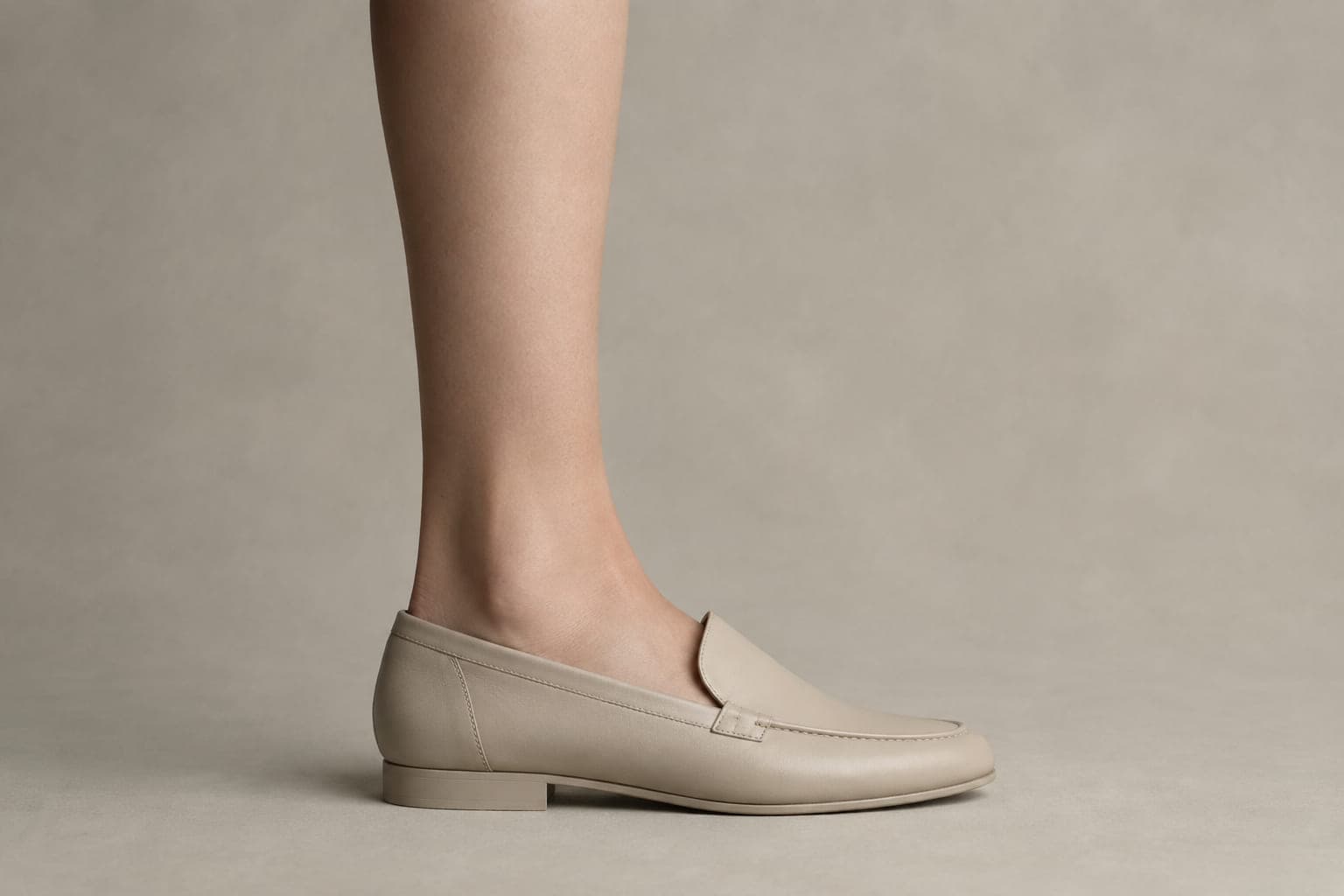 The same foot inside a shoe with an opening above the cuff height, showing no sock above the shoe.