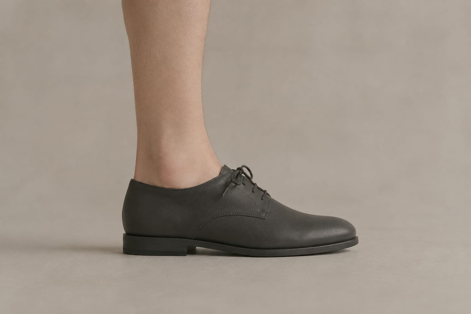 The same foot inside a shoe with an opening above the cuff height, showing no sock above the shoe.